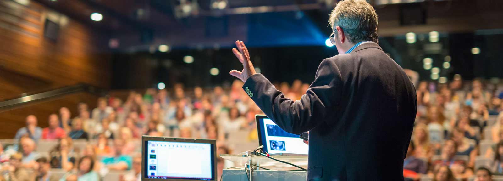 professional speaks to a crowd in an auditorium